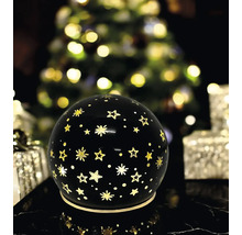Boule lumineuse décorative noire avec motif d'étoiles dans une ambiance festive de Noël.