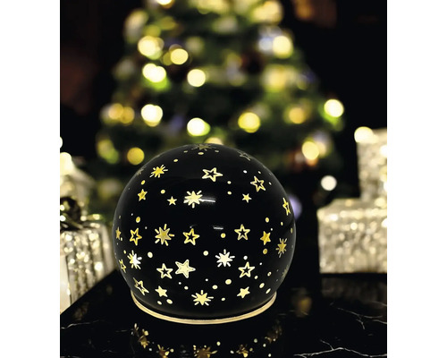 Boule lumineuse décorative noire avec motif d'étoiles dans une ambiance festive de Noël.