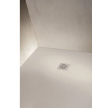 Vue détaillée d'un receveur de douche blanc avec un couvercle de bonde carré au motif en étoile et Laufen Logo.