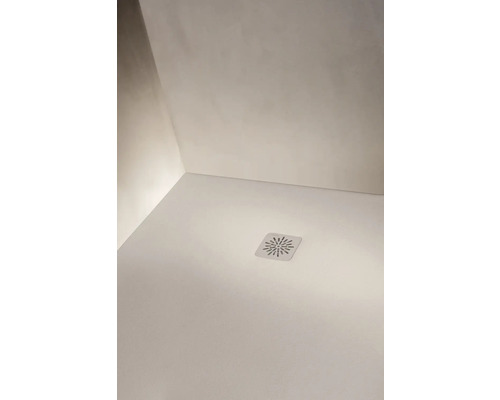 Vue détaillée d'un receveur de douche blanc avec un couvercle de bonde carré au motif en étoile et Laufen Logo.