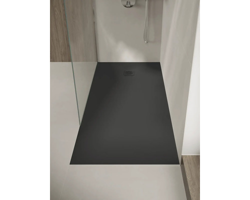Receveur de douche rectangulaire plat de couleur anthracite avec une grille carrée, installé dans une douche moderne avec paroi en verre.