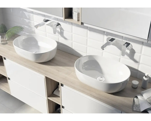 Salle de bain moderne avec deux vasques à poser ovales en céramique blanche sur un meuble sous-vasque clair et robinetterie murale.
