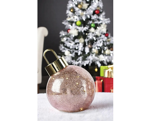 Boule de Noël LED avec effet craquelé et capuchon doré devant un sapin de Noël décoré avec des cadeaux.