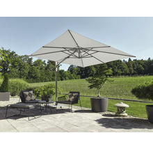 Parasol déporté carré dans un jardin moderne avec fauteuils, table basse et jardinières sur une terrasse pavée.