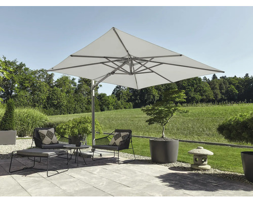 Parasol déporté carré dans un jardin moderne avec fauteuils, table basse et jardinières sur une terrasse pavée.