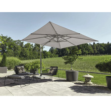 Terrasse moderne avec un grand parasol déporté carré au-dessus de fauteuils gris foncé et de jardinières, avec vue sur un paysage verdoyant.