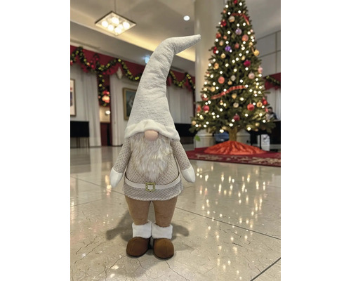 Weihnachtsgnom Dekofigur mit spitzem Hut und langem Bart in einem hellen Raum mit geschmücktem Weihnachtsbaum.