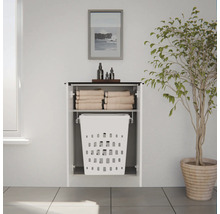 Armoire à linge murale blanche moderne avec compartiment ouvert pour serviettes et panier à linge intégré dans une pièce lumineuse.