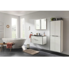 Modernes Badezimmer mit freistehender Badewanne, wandhängendem Waschtischunterschrank und hohem Badschrank in Weiss mit schwarzen Akzenten.