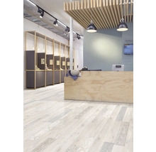 Espace de vente moderne avec sol design clair aspect bois, lames décorées, comptoir en bois et éclairage industriel au plafond.