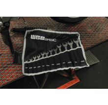 Jeu de 12 clés plates WGB BASIC, dimensions en pouces de un quart à quinze seizièmes de pouce, dans une trousse noire dans un atelier.