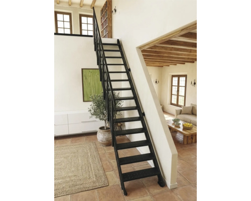 Schwarze Metalltreppe mit Geländer in einem hellen Raum mit Terrakottaboden und Holzbalkendecke.