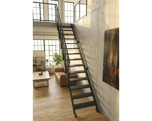 Schwarze Metalltreppe im Industriestil in einem hellen Loft mit Sichtbetonwand, Holzfußboden und Ledersofa.
