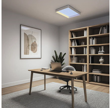 Modernes, helles Heimbüro mit Holzschreibtisch, Laptop, grauem Stuhl, großem Holzregal, Wandbild und einer quadratischen Deckenleuchte.