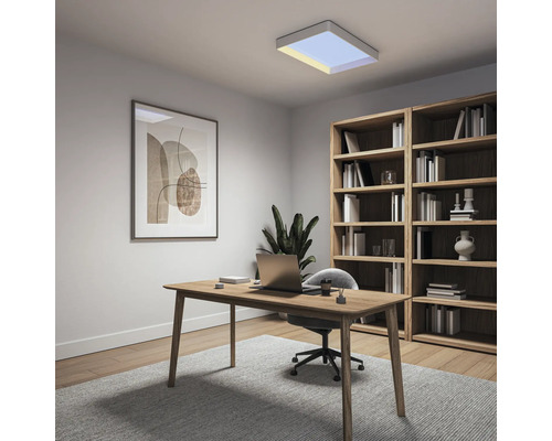 Modernes, helles Heimbüro mit Holzschreibtisch, Laptop, grauem Stuhl, großem Holzregal, Wandbild und einer quadratischen Deckenleuchte.