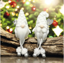Zwei weiße Weihnachts-Wichtel mit spitzen Mützen auf einem Holzstamm, einer mit Stern und einer mit Herz, vor festlichem Hintergrund.