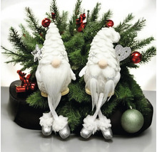 Zwei dekorative Weihnachtsgnome mit weißen Bärten und hängenden Beinen vor Tannenzweigen mit rotem Weihnachtsschmuck.