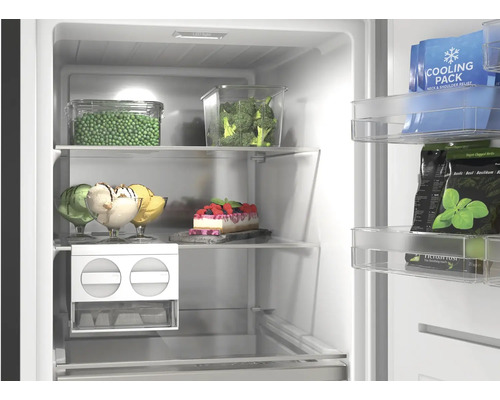 Vue intérieure lumineuse d'un congélateur organisé avec clayettes en verre, légumes, glaces, gâteau et fabrique de glaçons.