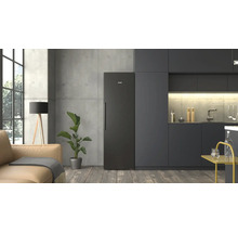 Cuisine moderne au style industriel avec réfrigérateur Siemens noir, meubles sombres, mur en béton, parquet et espace de vie adjacent.