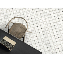 Moderne Bodenfliesen mit geometrischem Muster, Holzsitz und dunkler Schreibtisch mit Laptop in einer hellen Raumsituation.