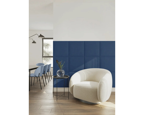 Quadratische Wandpaneele in einem modern eingerichteten Wohnzimmer mit hellem Sessel und Beistelltisch.