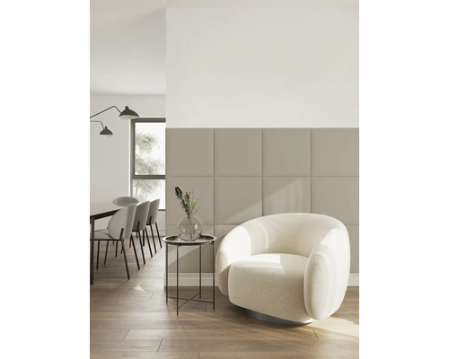 Modernes Wohnzimmer mit quadratischen Wandpaneelen, weißem Sessel und Holzfußboden in hellem, minimalistischem Design.