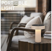 Lampe de table à LED portable avec panneau solaire sur une table d'appoint en bois dans un cadre extérieur chaleureux sur une terrasse.