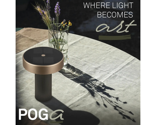 Lampe de table solaire POGA sur une table de jardin avec nappe à côté d'un vase en verre avec des fleurs.