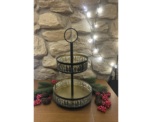 Zweistöckige Etagere aus Metall in Schwarz und Gold mit Tannenbaum-Muster und Merry Christmas-Schriftzug, dekoriert auf einem Holztisch.