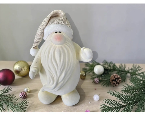 Dekorative Weihnachtsmann-Figur aus weichem Material mit langem Bart und Zipfelmütze in einer weihnachtlichen Umgebung.