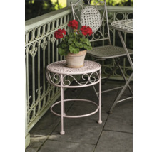 Runder Garten-Beistelltisch aus Metall mit dekorativen Verzierungen und einem Blumentopf auf einer Terrasse mit Geländer.