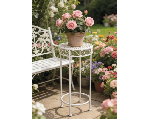 Weißer Pflanzenständer aus Metall und weiße Gartenbank in einem hellen Garten mit Blumen auf einer Steinterrasse.