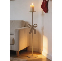 Bodenkerzenständer mit dekorativer Schleife, hoher Stab und Stumpenkerze, im Wohnzimmer neben einem Sofa platziert.