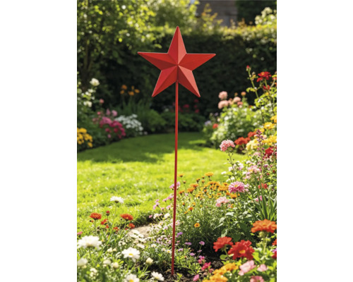 Roter Gartenstecker aus Metall in Sternform in einem hellen, bunt bepflanzten Blumenbeet mit Rasenfläche im Hintergrund.