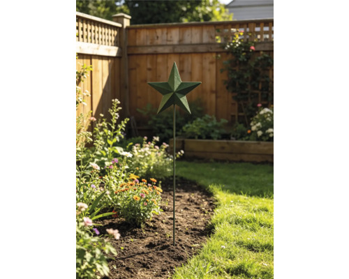 Gartenstecker aus Metall mit einem Stern in einem bepflanzten Blumenbeet vor einem Holzzaun.