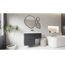 Salle de bain moderne avec meuble sous-vasque anthracite asymétrique, trois miroirs de forme organique, une baignoire blanche et une plante.