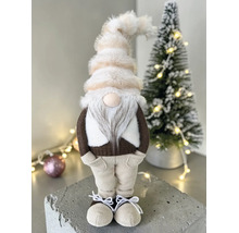 Dekorativer Wichtel mit Plüschmütze, Bart und Textilkleidung neben einem kleinen Weihnachtsbaum.