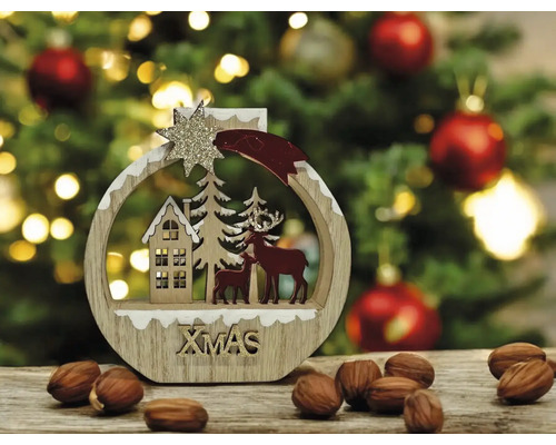 Weihnachtsdekoration aus Holz in runder Form mit winterlicher Szene, Haus, Tannen und Hirschen sowie glitzerndem Xmas-Schriftzug.