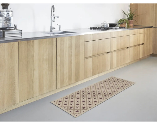 Helle, moderne Küche mit Holzschränken und einem langen Läufer mit geometrischem Sternmuster auf dem Boden.