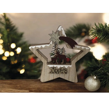 Weihnachtsdekoration Holzstern mit Rentier-Silhouette, Tannenbäumen und glitzerndem XMAS-Schriftzug vor weihnachtlichem Hintergrund.