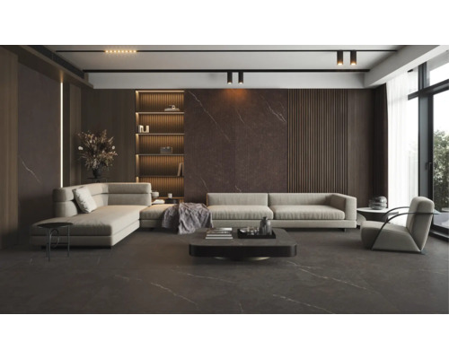 Salon moderne avec carrelage sombre aspect marbre au sol et aux murs, canapé d'angle beige et étagères intégrées éclairées.