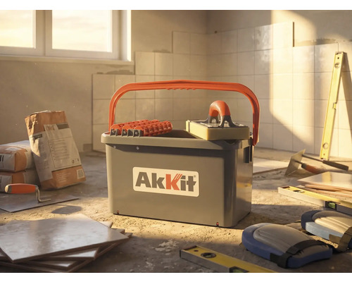 Kit de nettoyage pour carrelage AkKit avec seau, rouleaux et taloche éponge sur un chantier avec carrelage et outils.