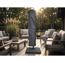 Housse de protection pour parasol sur une terrasse en bois organisée avec meubles de salon modernes, guirlande lumineuse et brasero.