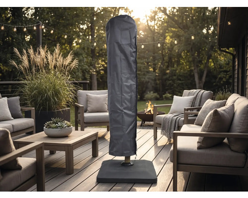 Housse de protection pour parasol sur une terrasse en bois organisée avec meubles de salon modernes, guirlande lumineuse et brasero.