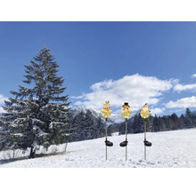 Drei solarbetriebene Gartenstecker in Form von Rentier, Schneemann und Weihnachtsmann, leuchtend in einer verschneiten Winterlandschaft.