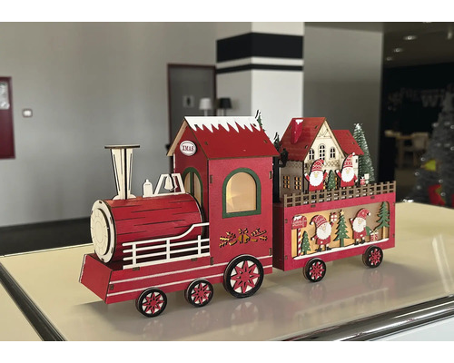 Rote Weihnachtsdekoration Holzzug mit LED-Beleuchtung, bestehend aus Lokomotive und Wagen mit Weihnachtsmann-Figuren und Häusern.