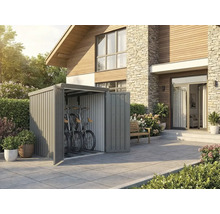 Abri à vélos moderne en métal gris sur une terrasse à côté d une maison. Deux vélos sont rangés à l intérieur.