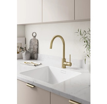 Moderne helle Küche mit einer Hochbogen-Küchenarmatur, einem Unterbaubecken und einer Arbeitsplatte in Steinoptik.