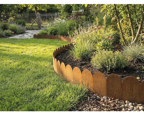 Bordure de pelouse ondulée en métal aspect rouille séparant un parterre de fleurs d'une pelouse dans un jardin clair.