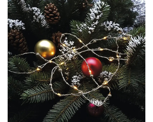 LED Drahtlichterkette auf Tannenzweigen mit Weihnachtskugeln und Tannenzapfen